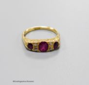 An early 20th century 18ct, three stone ruby and four stone diamond chip set half hoop ring, size