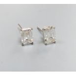 A modern pair of white metal and solitaire emerald cut diamond set ear studs, gross weight 1.1