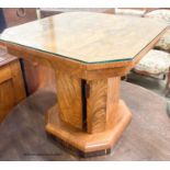 An Art Deco style octagonal figured walnut coffee table, with cupboard column, width 57cm, height