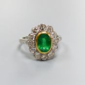 A modern platinum, emerald and diamond set oval cluster ring, size M, gross weight 5.2 grams.