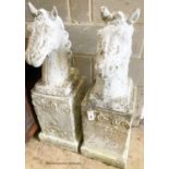 A pair of reconstituted stone horse's heads on plinth bases in the style of Austin and Seeley,
