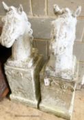 A pair of reconstituted stone horse's heads on plinth bases in the style of Austin and Seeley,