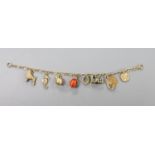 A 10k yellow metal oval link charm bracelet, hung with assorted mainly 9ct gold charms, gross