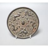 A Chinese bronze mirror, cast with vines and hounds, 14cm