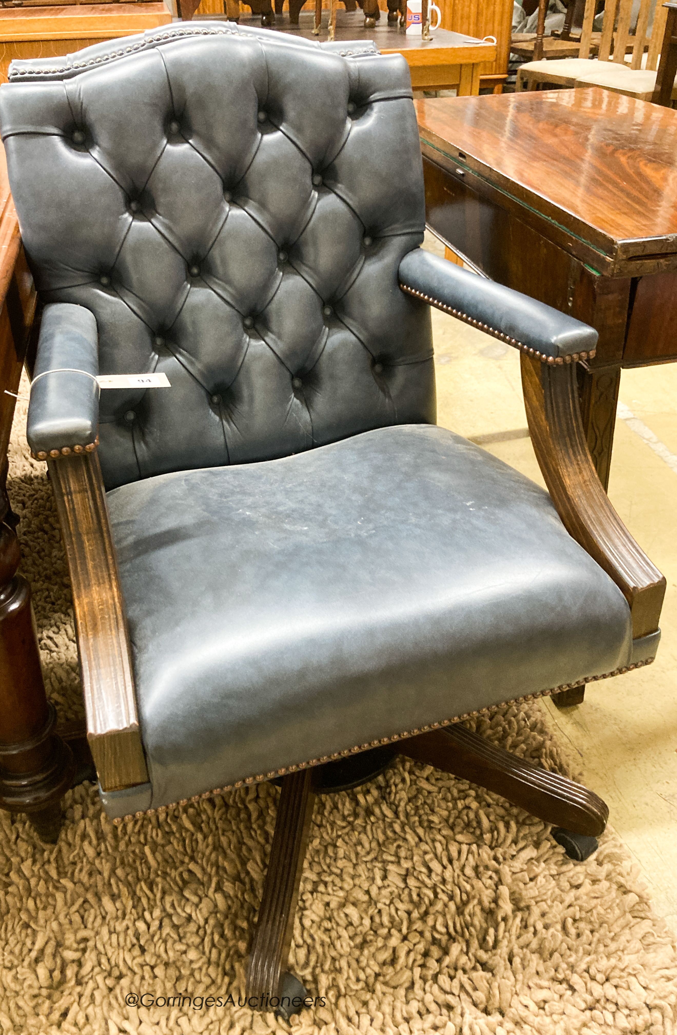 A pair of reproduction beech buttoned blue leather swivel desk chairs, width 60cm, depth 55cm,