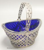 A 19th century Dutch pierced white metal boat shaped sugar basket, with blue glass liner, length