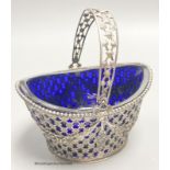 A 19th century Dutch pierced white metal boat shaped sugar basket, with blue glass liner, length