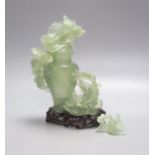 A Chinese green bowenite jade group modelled as a covered urn surrounded by a dragon, H 26cm with