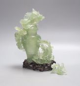 A Chinese green bowenite jade group modelled as a covered urn surrounded by a dragon, H 26cm with