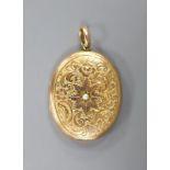 An early 20th century engraved yellow metal (stamped 9c) and split pearl set oval locket, 44mm,