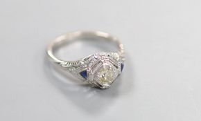 A 18ct white metal and single stone diamond ring, with triangular cut blue stone set shoulders,