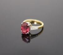 A modern 18ct gold and oval deep pink tourmaline ring, with diamond set shoulders,size Q, gross 4.3