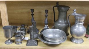 A French lidded pewter jug with double acorn thumbpiece, two pairs of pewter candlesticks and nine