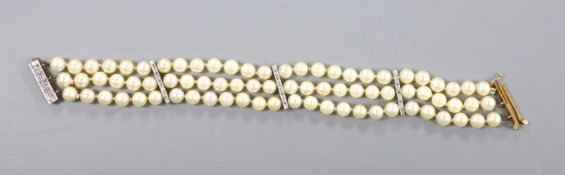 A triple strand cultured pearl bracelet, with yellow metal and diamond chip set spacers and clasp,