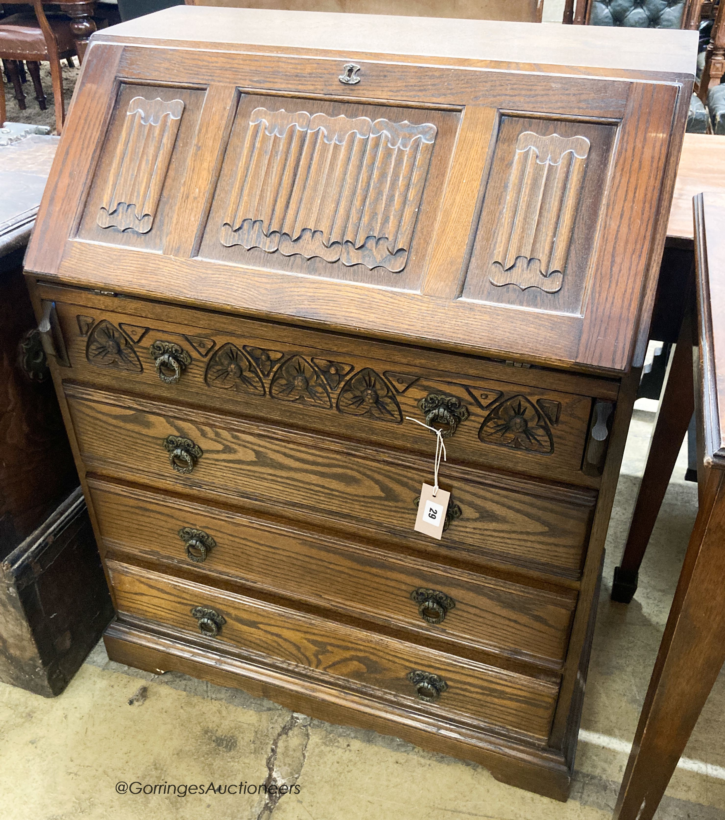 A reproduction oak linenfold carved bureau, W.75cm D.48cm H.99cm