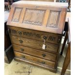 A reproduction oak linenfold carved bureau, W.75cm D.48cm H.99cm