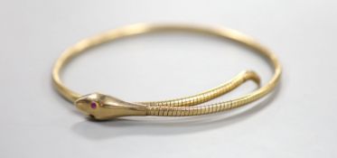 An early to mid 20th century 9ct coiled serpent bracelet, with gem set eyes (one missing), gross