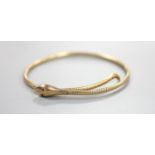 An early to mid 20th century 9ct coiled serpent bracelet, with gem set eyes (one missing), gross