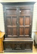 A carved oak cupboard, enclosed by panelled doors, bearing monograms and dated 1601, width 138cm,