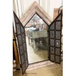 A medieval style simulated stone and wrought iron wall mirror, width 92cm, height 156cm