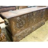 A 17th / 18th century Welsh oak coffer, with carved panelled front and heavy brass strap hinges, W.
