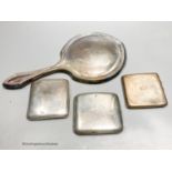 A George V silver mounted hand mirror and three silver cigarette cases.