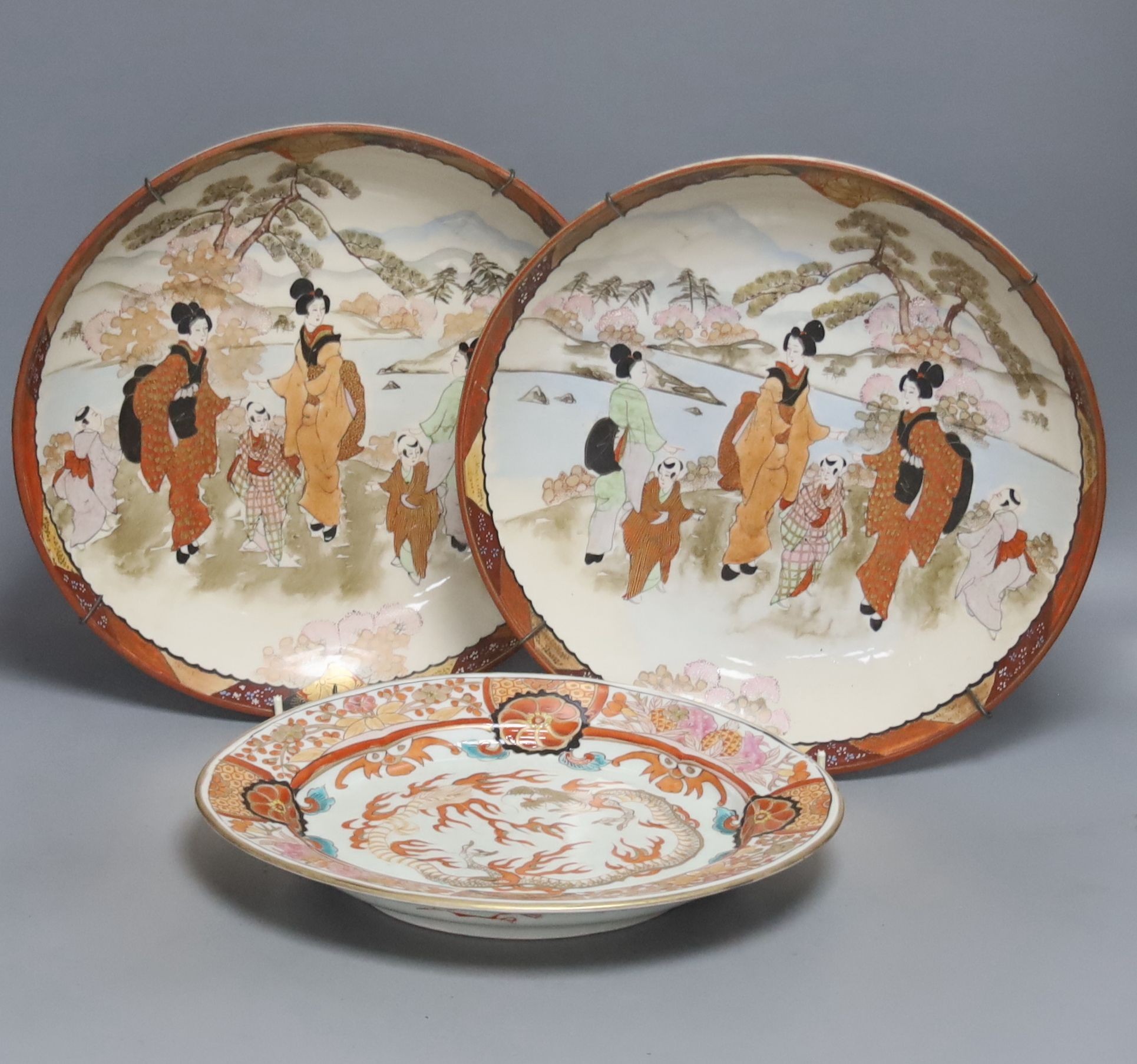 A late 19th century Japanese porcelain oval dish, 29cm, and a pair of Kutani style wall plates,