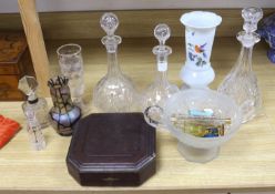 A collection of glass perfume bottles, three decanters, two scent bottles with cut glass stoppers