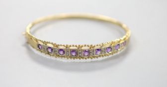 A modern 9ct gold and graduated nine stone amethyst set bracelet, with diamond chip set spacers,