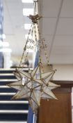 A gilt-metal star-shaped ceiling light, having etched plain glass panels and chain suspension,