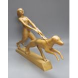 An Art Deco style light elm carving of a woman and dog on lead-weighted plinth, height 40cm