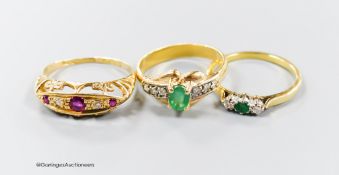 Three assorted modern 18ct gold and gem set rings, including emerald and diamond, ruby and diamond,