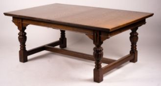 A 17th century style carved rectangular oak extending dining table with 'H' stretcher, 300cm
