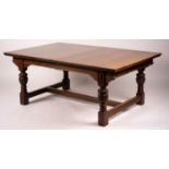 A 17th century style carved rectangular oak extending dining table with 'H' stretcher, 300cm