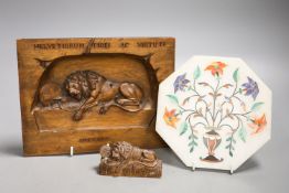 A walnut Lion of Lucerne plaque and carving and an Indian hardstone plaque