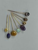 A small collection of eight assorted mainly yellow metal and chalcedony set stick pins, including