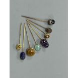 A small collection of eight assorted mainly yellow metal and chalcedony set stick pins, including