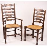 A set of ten 18th century style beech ladderback rush seat dining chairs, two with arms