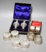 Four pairs of silver napkin rings including cased Victorian and a cased pair of silver pepperettes.