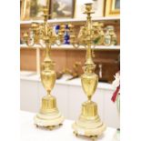 A pair of Louis XVI style four branch, five light gilt brass candelabra, with vase shaped stem, on