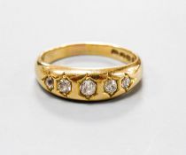 A late Victorian 18ct gold and graduated five stone gypsy set five stone ring, size Q, gross