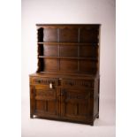 An 18th century style carved oak dresser, width 124cm, depth 46cm, height 175cm