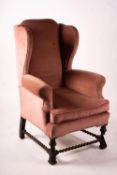An early 20th century Jacobean revival upholstered wing armchair, width 84cm, depth 90cm, height
