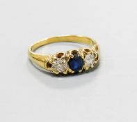 A yellow metal, sapphire and diamond set three stone ring, size S, gross weight 5.6 grams.