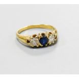 A yellow metal, sapphire and diamond set three stone ring, size S, gross weight 5.6 grams.