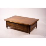 A reproduction rectangular walnut coffee table with rising top enclosing a wine bottle storage