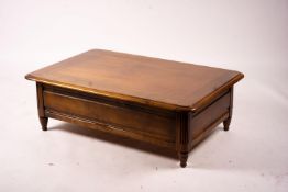A reproduction rectangular walnut coffee table with rising top enclosing a wine bottle storage