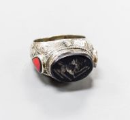 A continental engraved white metal and oval intaglio black onyx ring, with two colour enamel set