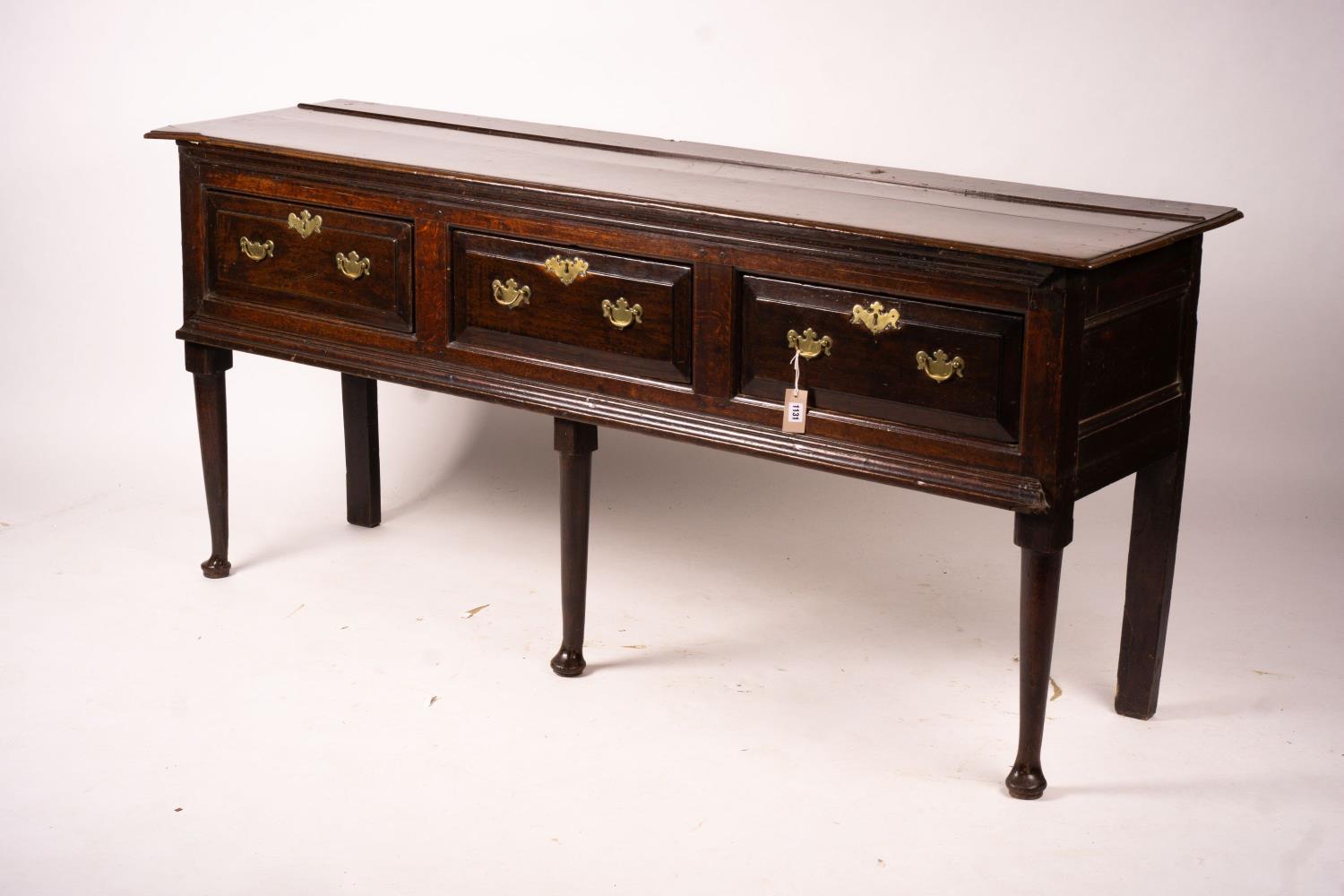 An 18th century oak low dresser on pole turned legs and pad feet, length 198cm, depth 53cm, height