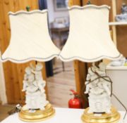 A pair of Sevres style biscuit porcelain groups of putti, fitted as a table lamps with shades69cm